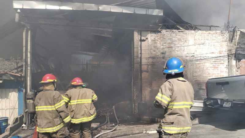 Equipos tácticos de Bomberos trabajan en la extinción del incendio en una chatarrera ubicada en la 34.ª Avenida Norte de San Salvador.