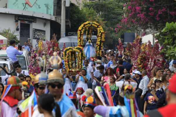 Pobladores de Panchimalco desfilan con las varas de flores tradicionales durante la celebración dedicada a la Virgen del Rosario este domingo. Cortesía.