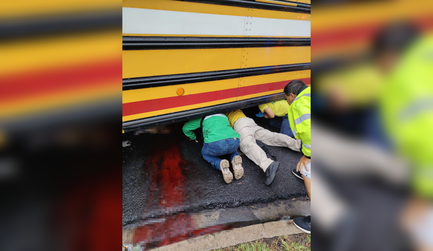 Una estudiante de la UES murió atropellada por un autobús de la ruta 1 en la avenida Don Bosco. El accidente ocurrió mientras intentaba subir al transporte bajo la lluvia. Foto: Comandos de Salvamento.